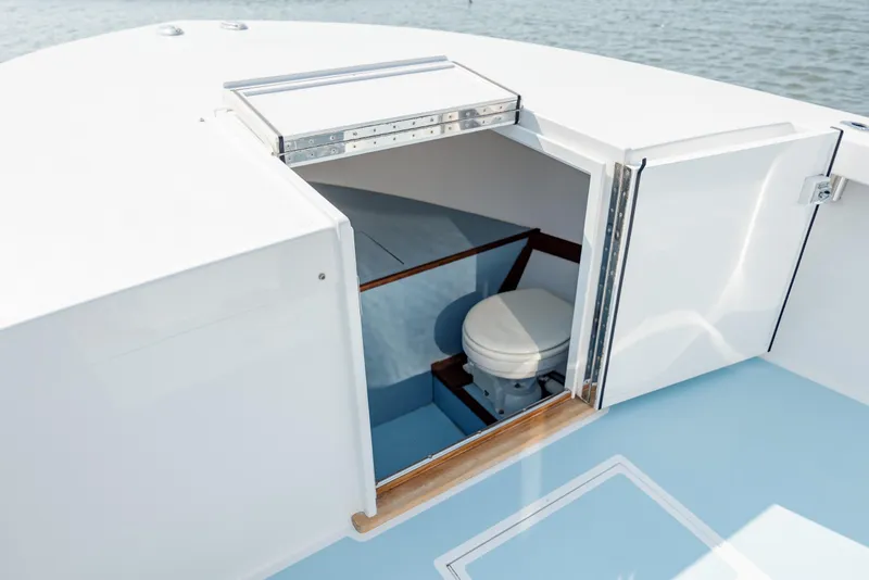 Slide: The Image of 2019 Gamefisherman 26 Cuddy Cabin boat with open hatch revealing interior toilet. - 41