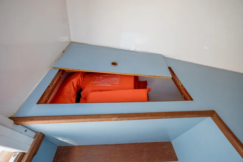 Slide: The Image of 2019 Gamefisherman 26 Cuddy Cabin storage with orange life jackets. - 44