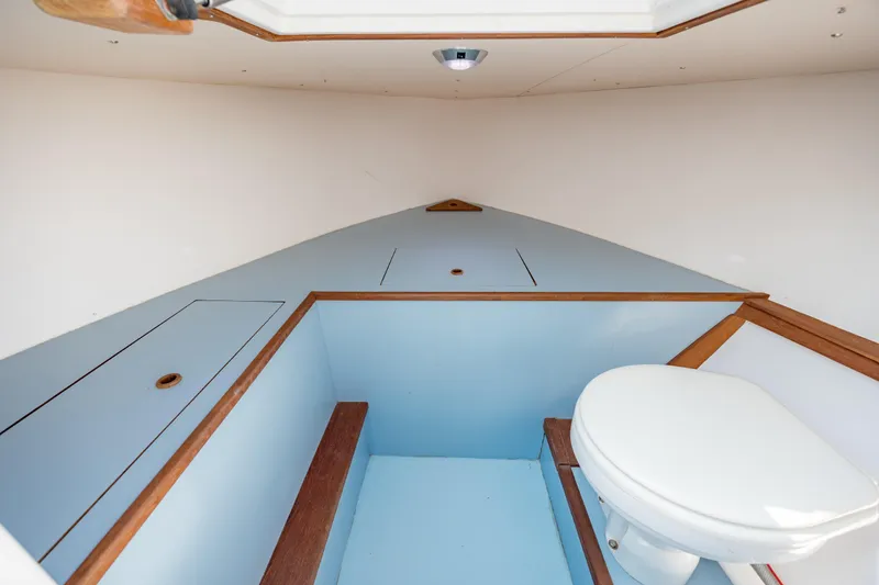 Slide: The Image of 2019 Gamefisherman 26 Cuddy Cabin interior with toilet and storage compartments. - 45