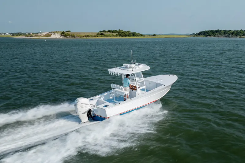 Slide: The Image of 2019 Gamefisherman 26 Cuddy Cabin cruising on open water, showcasing sleek design and performance. - 53