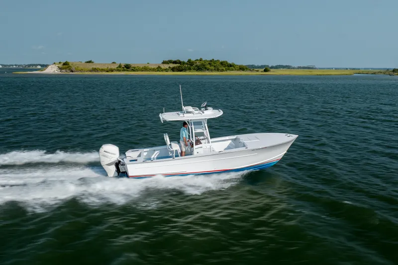 Slide: The Image of 2019 Gamefisherman 26 Cuddy Cabin cruising on open water near a small island. - 55