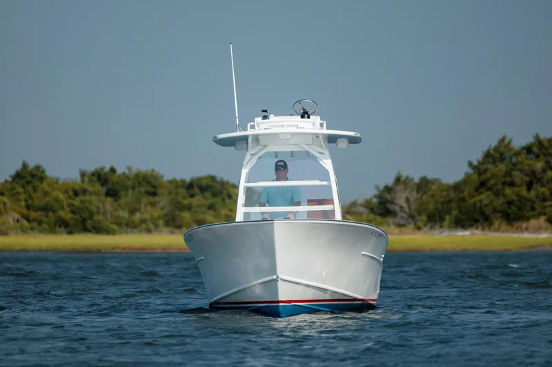 Slide: The Image of 2019 Gamefisherman 26 Cuddy Cabin boat cruising on open water. - 8