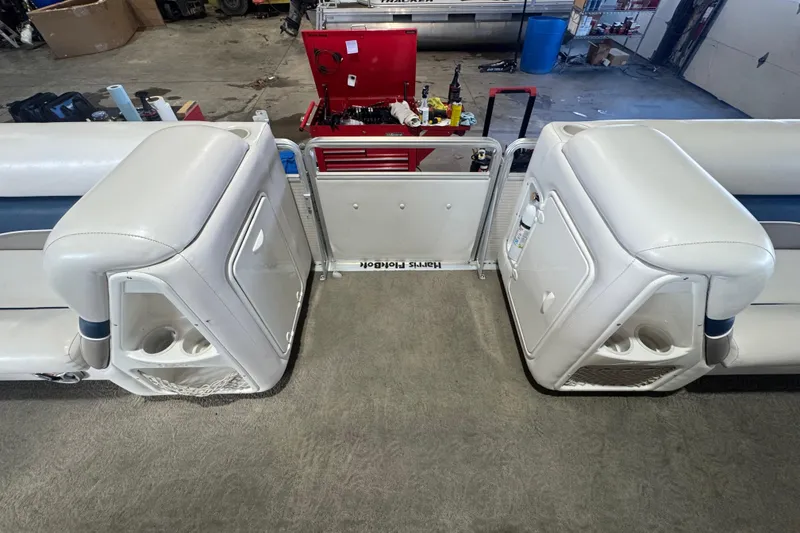 Slide: The Image of 2005 Harris FloteBote 260 Classic pontoon boat interior with white seating and storage compartments. - 11