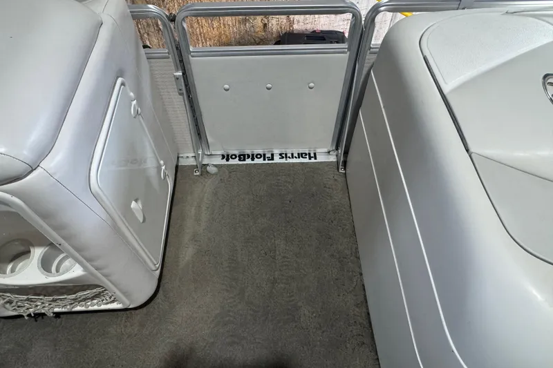 Slide: The Image of Interior of 2005 Harris FloteBote 260 Classic pontoon boat, featuring seating and storage. - 12