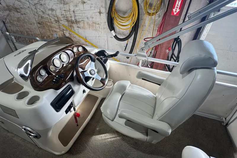 Slide: The Image of 2005 Harris FloteBote 260 Classic boat helm with steering wheel and captain's chair. - 14