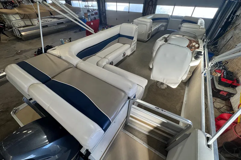 Slide: The Image of 2005 Harris FloteBote 260 Classic pontoon boat interior with white and blue seating. - 17