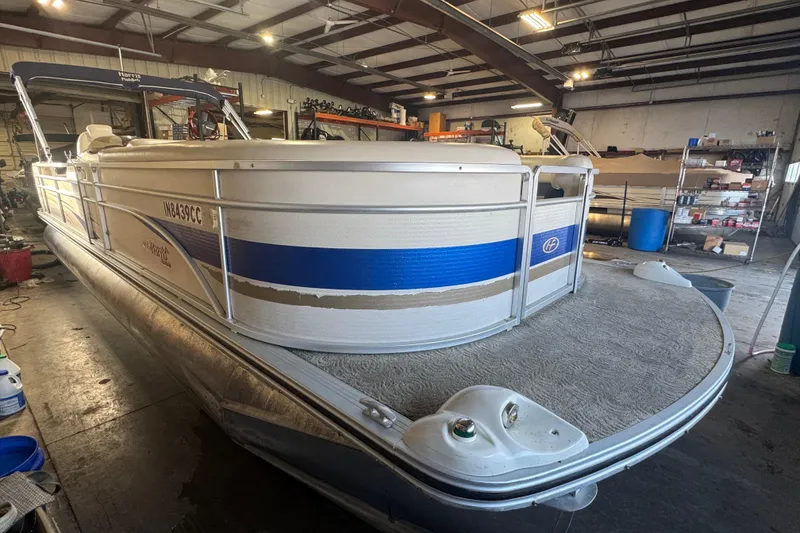 Slide: The Image of 2005 Harris FloteBote 260 Classic pontoon boat in a workshop setting. - 2