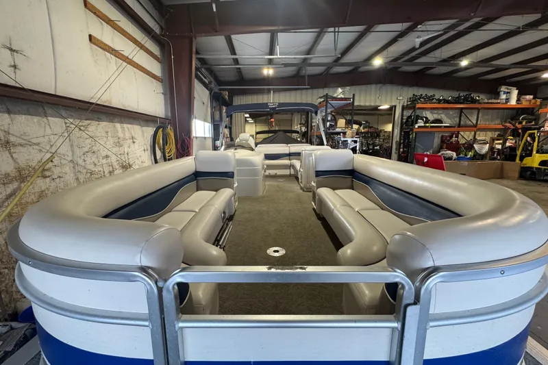 Slide: The Image of 2005 Harris FloteBote 260 Classic pontoon boat interior in a warehouse setting. - 4