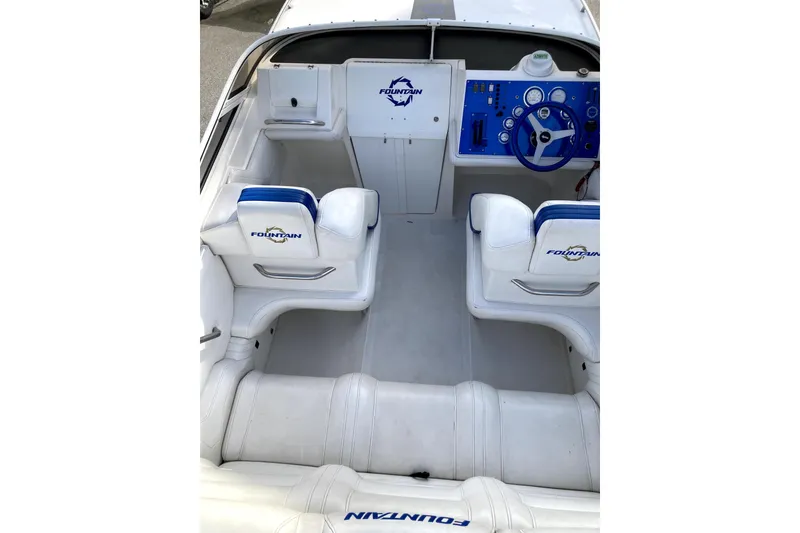 Slide: The Image of 2003 Fountain 27 Fever boat interior with white seating and blue dashboard. - 9
