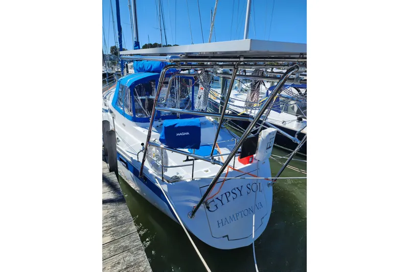 The Image of 1987 Irwin 44 sailboat docked, featuring blue accents and "Gypsy Sol" name. - 0