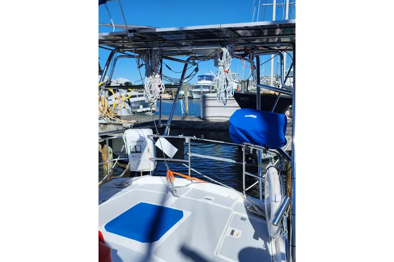 Slide: The Image of 1987 Irwin 44 sailboat docked, featuring deck equipment and marina background. - 12