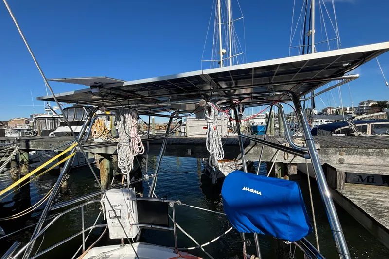 Slide: The Image of 1987 Irwin 44 sailboat with solar panels and marina backdrop. - 13