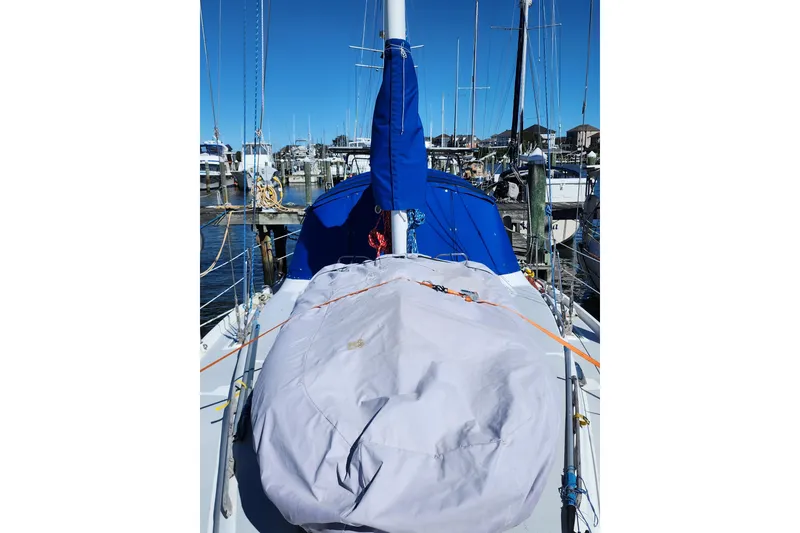 Slide: The Image of 1987 Irwin 44 sailboat docked, covered deck, blue and white color scheme. - 18