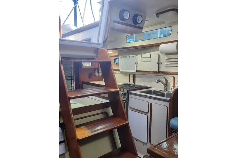 Slide: The Image of Interior of 1987 Irwin 44 sailboat with wooden stairs and compact kitchen area. - 22