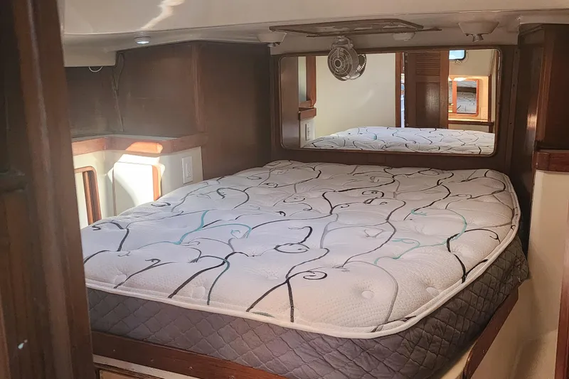 Slide: The Image of 1987 Irwin 44 yacht interior cabin with comfortable bed and wooden accents. - 26