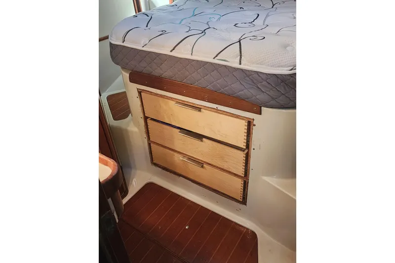 Slide: The Image of 1987 Irwin 44 interior with wooden drawers and mattress, showcasing storage space. - 27
