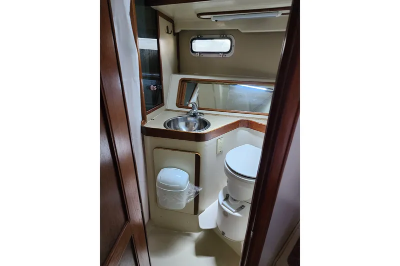 Slide: The Image of 1987 Irwin 44 yacht bathroom with sink, toilet, and wooden accents. - 31