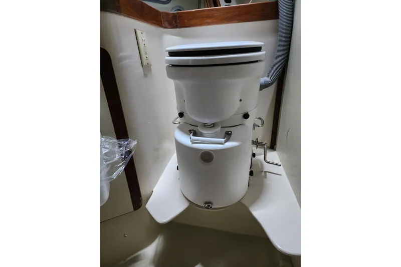 Slide: The Image of Marine toilet in 1987 Irwin 44 sailboat bathroom, featuring compact design and plumbing. - 42