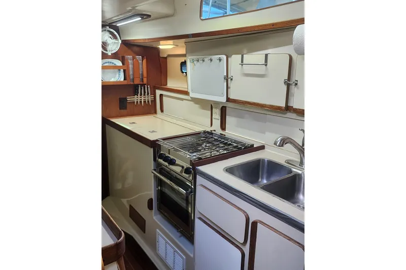 Slide: The Image of 1987 Irwin 44 yacht kitchen with stove, sink, and storage cabinets. - 50