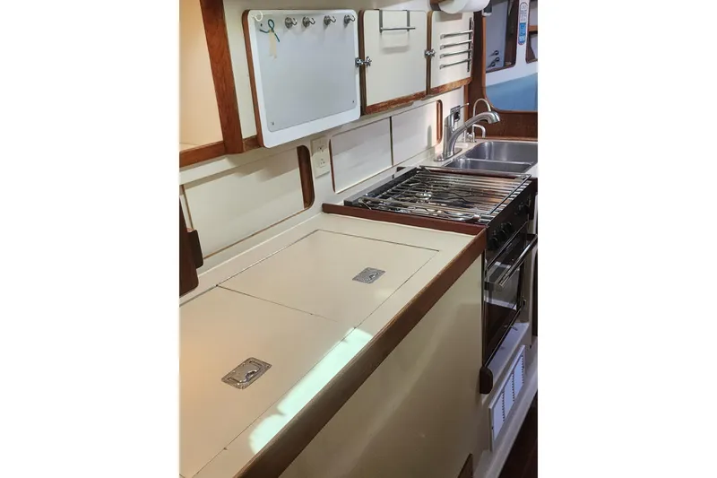 Slide: The Image of 1987 Irwin 44 yacht kitchen with stove, sink, and storage cabinets. - 51