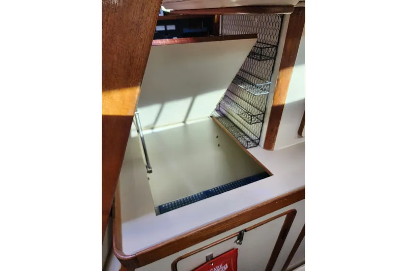 Slide: The Image of 1987 Irwin 44 yacht interior with open storage compartment and wooden finish. - 52