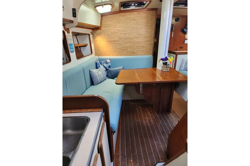 Slide: The Image of Cozy interior of 1987 Irwin 44 sailboat with blue seating and wooden table. - 58