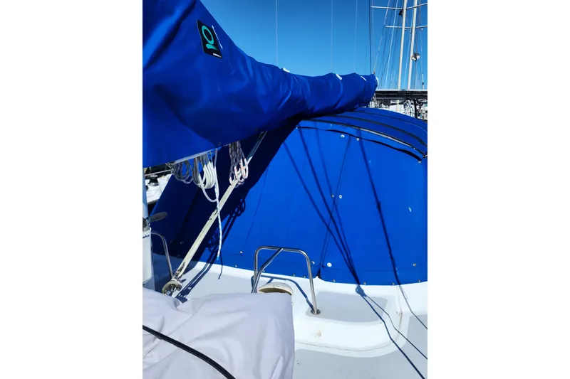 Slide: The Image of 1987 Irwin 44 sailboat with blue canvas cover and rigging details. - 6