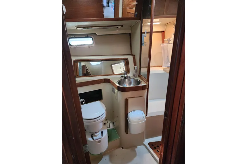 Slide: The Image of 1987 Irwin 44 yacht bathroom with sink, toilet, and mirror. - 62