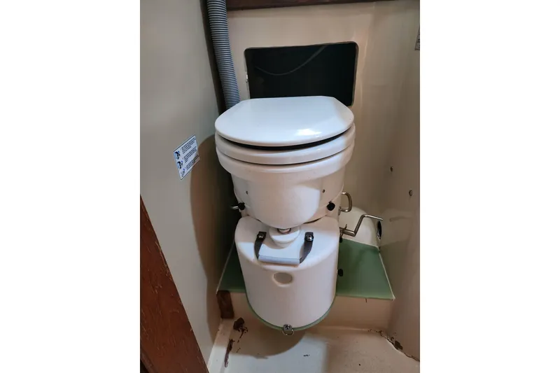Slide: The Image of 1987 Irwin 44 marine toilet in compact bathroom setting. - 63