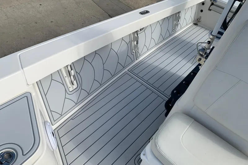 Slide: The Image of 2017 Pathfinder 2400 TRS boat interior with sleek, patterned flooring and white seating. - 12