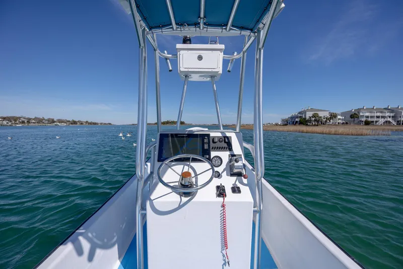 Slide: The Image of 2021 Imemsa W25BA boat on calm water, featuring a steering console and clear blue sky. - 13