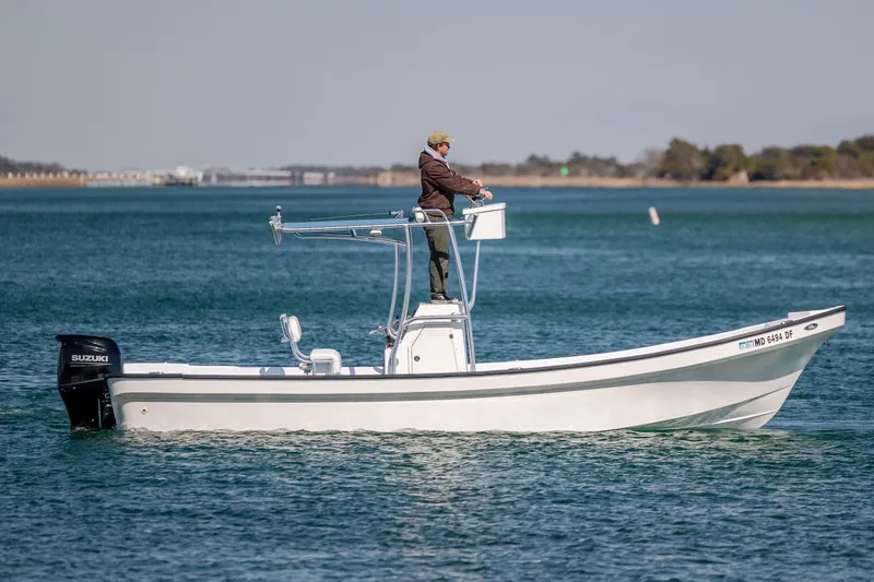 Slide: The Image of 2021 Imemsa W25BA boat with Suzuki engine on calm water, person steering. - 6