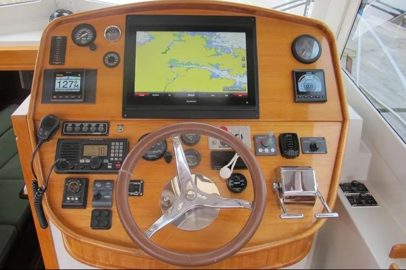 Slide: The Image of 2005 Lyman-Morse Monhegan boat helm with navigation equipment and wooden steering wheel. - 11