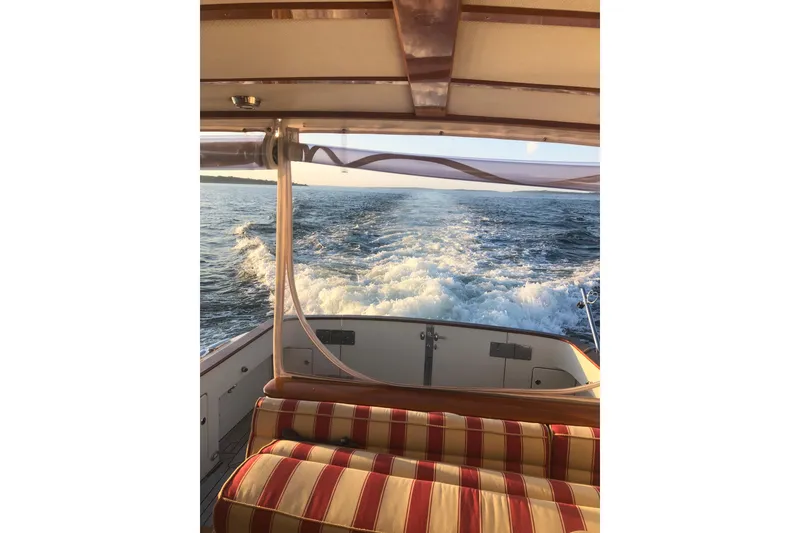 Slide: The Image of 2005 Lyman-Morse Monhegan boat interior with striped seating, ocean view, and wake. - 12