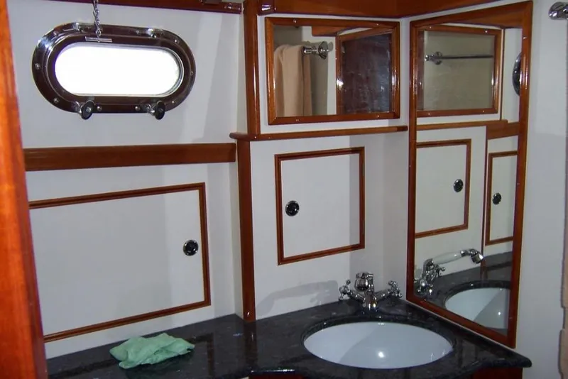 Slide: The Image of Elegant 2005 Lyman-Morse Monhegan yacht bathroom with wood accents and porthole window. - 18