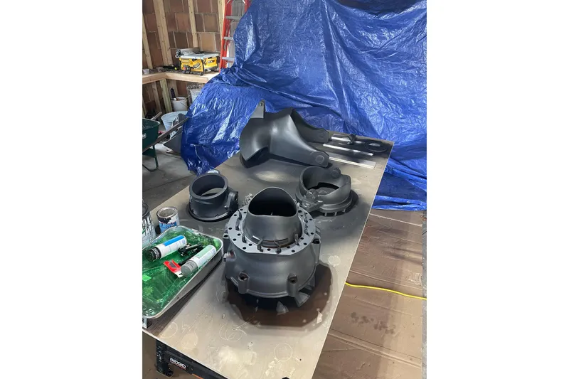 Slide: The Image of Black mechanical parts on a workbench, Lyman-Morse Monhegan 2005, with tools and blue tarp background. - 20