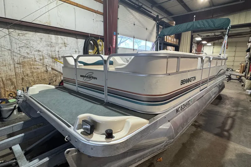 Slide: The Image of 2000 Bennington 205 L pontoon boat in a garage, side view. - 1