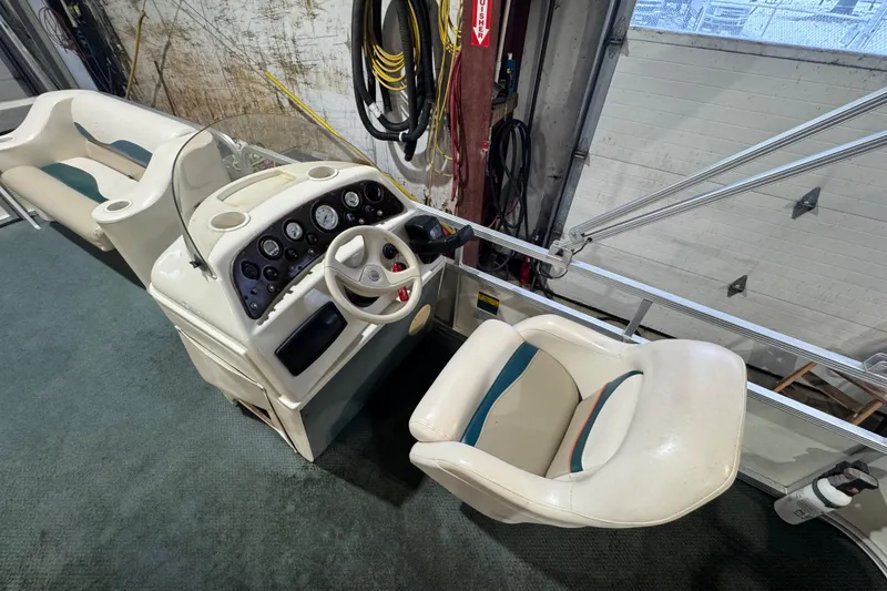 Slide: The Image of 2000 Bennington 205 L boat interior with steering console and seating. - 10