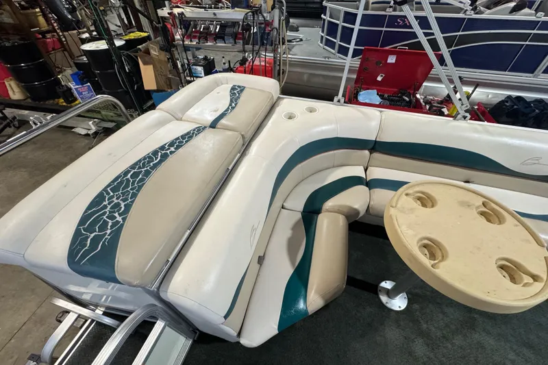 Slide: The Image of Bennington 205 L 2000 boat interior with beige and teal seating and table. - 11