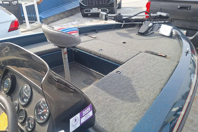 Slide: The Image of 1994 Ranger 481VS boat interior with dashboard and seating, parked outdoors. - 11