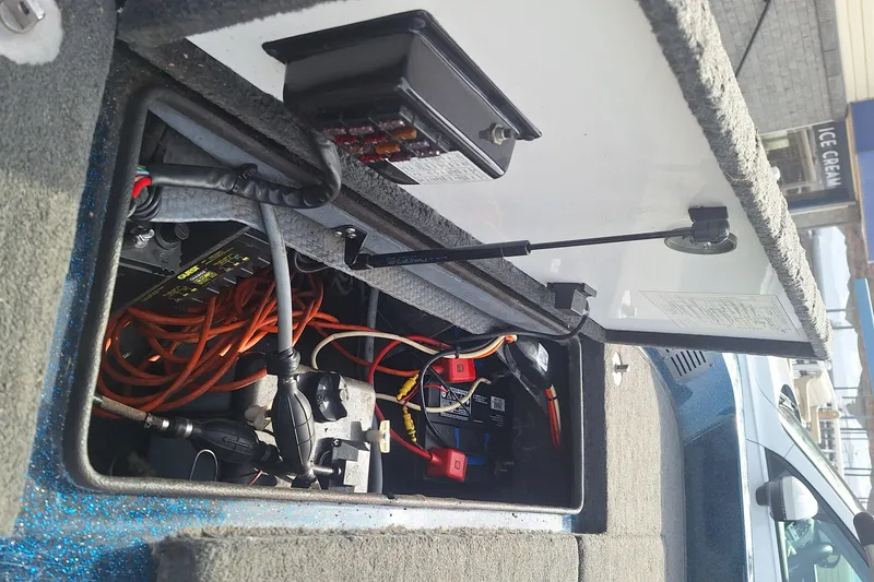 Slide: The Image of Open storage compartment in a 1994 Ranger 481VS boat, showing electrical wiring and components. - 16