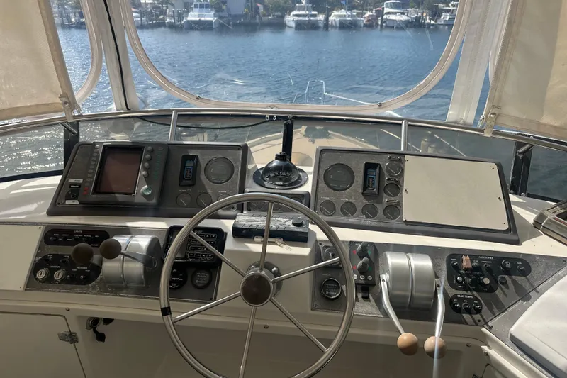 Slide: The Image of 1991 Carver Californian 48 yacht helm with steering wheel and navigation controls. - 18