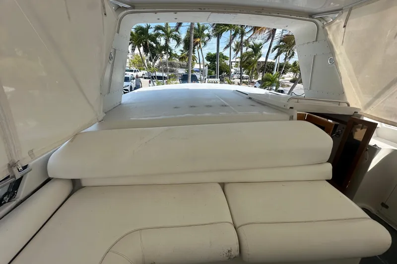 Slide: The Image of 1991 Carver Californian 48 yacht interior with white seating and tropical view. - 19