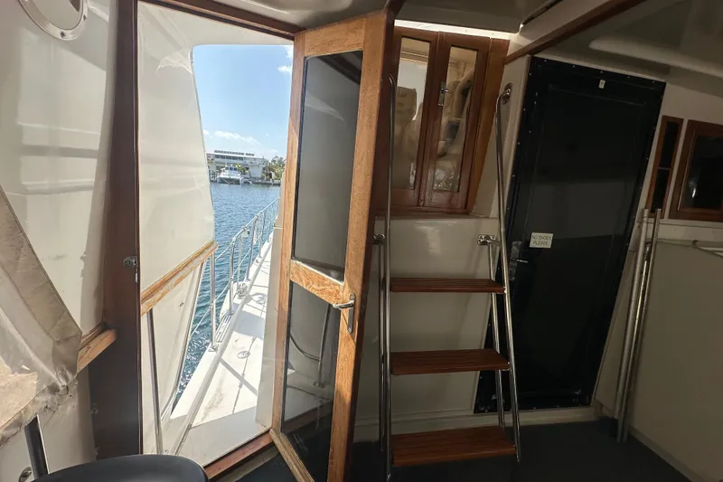 Slide: The Image of Interior view of 1991 Carver Californian 48 yacht with open door and wooden stairs. - 25