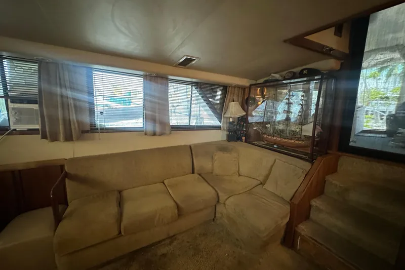 Slide: The Image of Interior of 1991 Carver Californian 48 yacht with beige sofa and model ship display. - 44