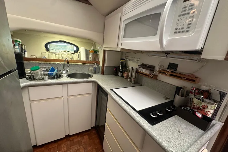 Slide: The Image of Compact kitchen in 1991 Carver Californian 48 yacht with microwave, sink, and stove. - 48