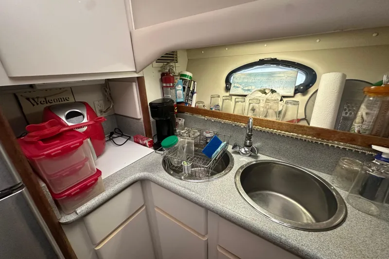 Slide: The Image of Compact kitchen area in a 1991 Carver Californian 48 yacht with sink and storage. - 52