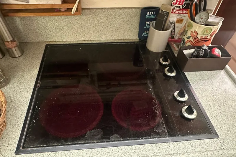 Slide: The Image of Stovetop in a 1991 Carver Californian 48 yacht kitchen, with various cooking utensils nearby. - 53