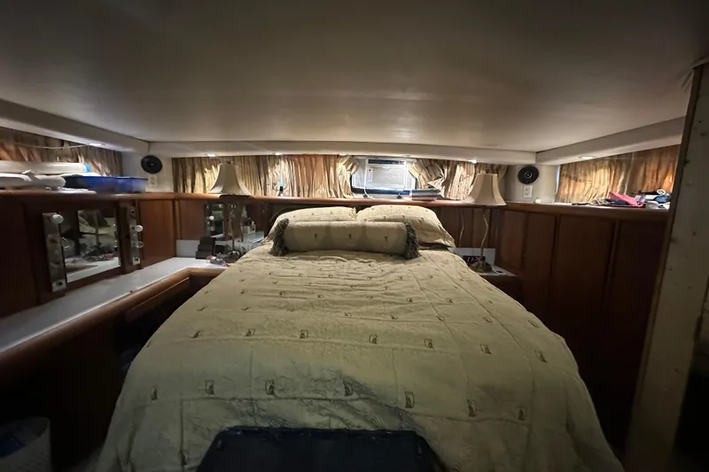 Slide: The Image of Luxurious bedroom interior of 1991 Carver Californian 48 yacht with cozy bedding and ambient lighting. - 55