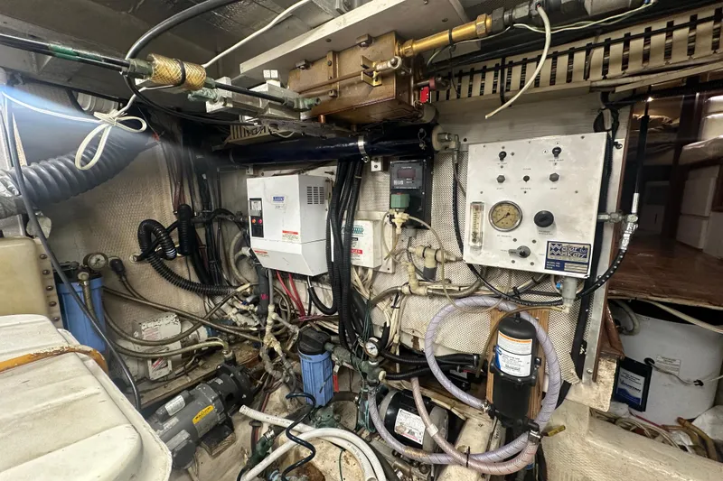 Slide: The Image of Engine room of a 1991 Carver Californian 48 yacht, showcasing complex machinery and wiring. - 67